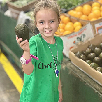 Young girl holding avocado